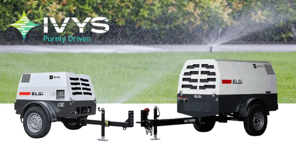 Compresseurs d’air portatifs ELGi avec marquage IVYS « Purement propulsé », positionnés sur une pelouse avec arroseurs en arrière-plan. Équipement mobile pour purge d’irrigation, hivernisation de systèmes extérieurs, compresseurs professionnels pour applications commerciales.